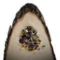 Blütenzauber essbare Blüten von Der Kräuterteufel, lose auf einer natürlichen Holzscheibe mit Rinde
