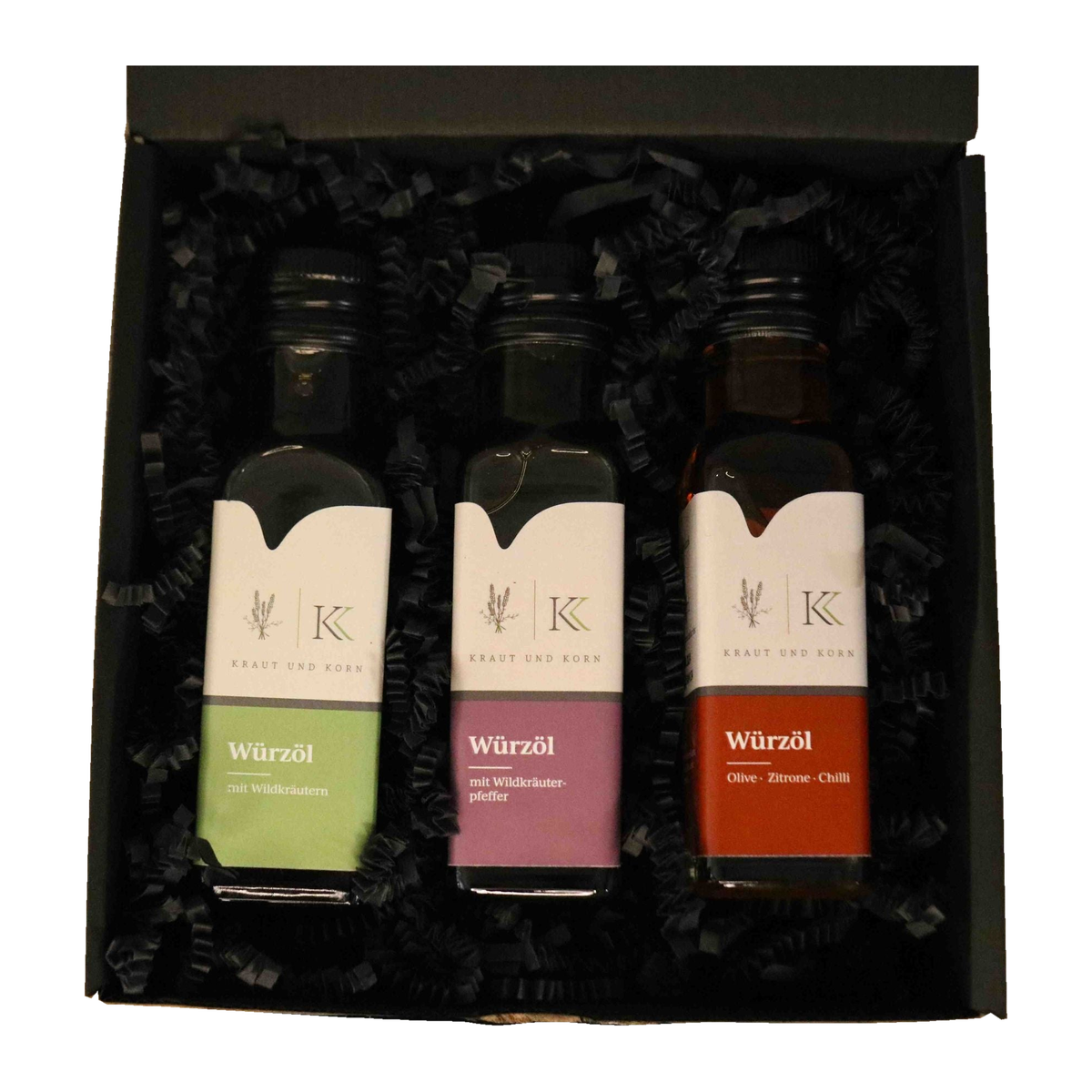 Würzöl-Geschenkset von Kraut & Korn mit drei 100-ml-Flaschen in offener schwarzer Geschenkbox