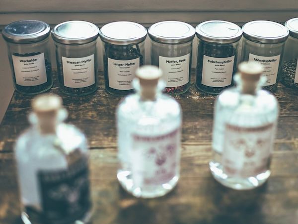 Euelsberger-Ginflaschen vor Gläsern mit Botanicals